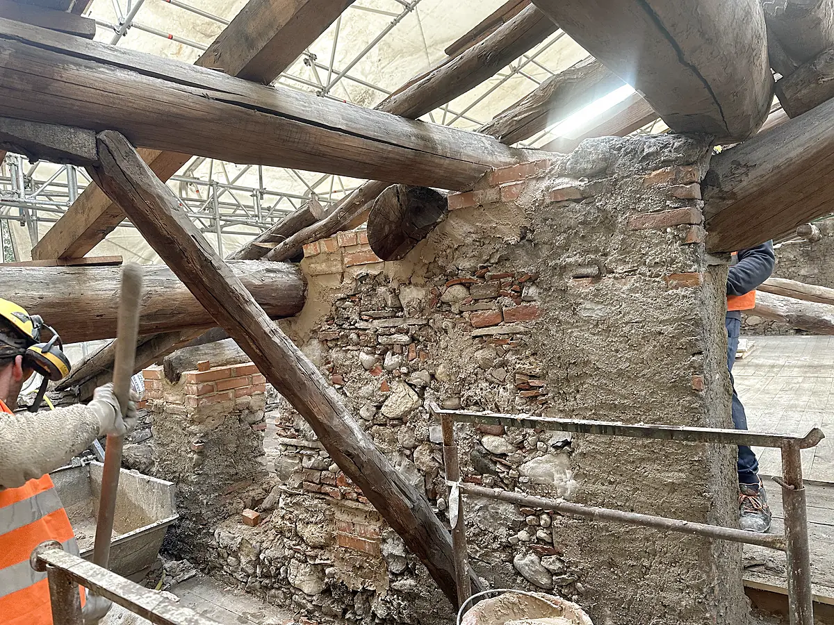 Ricostruzione con mattoni pieni della testa di un muro in pietra sotto l'appoggio delle travi